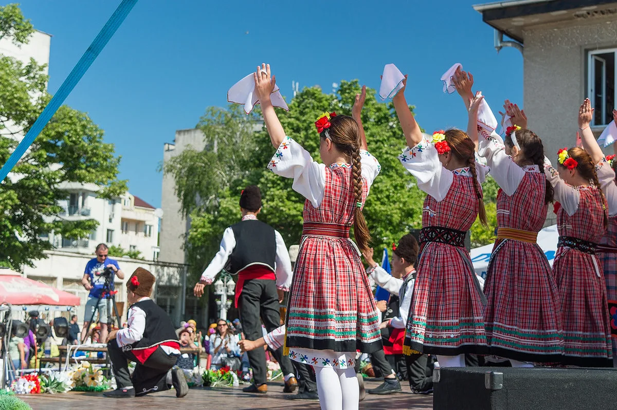 Bulgarian performers in traditional folk costumes dancing the horo circle dance