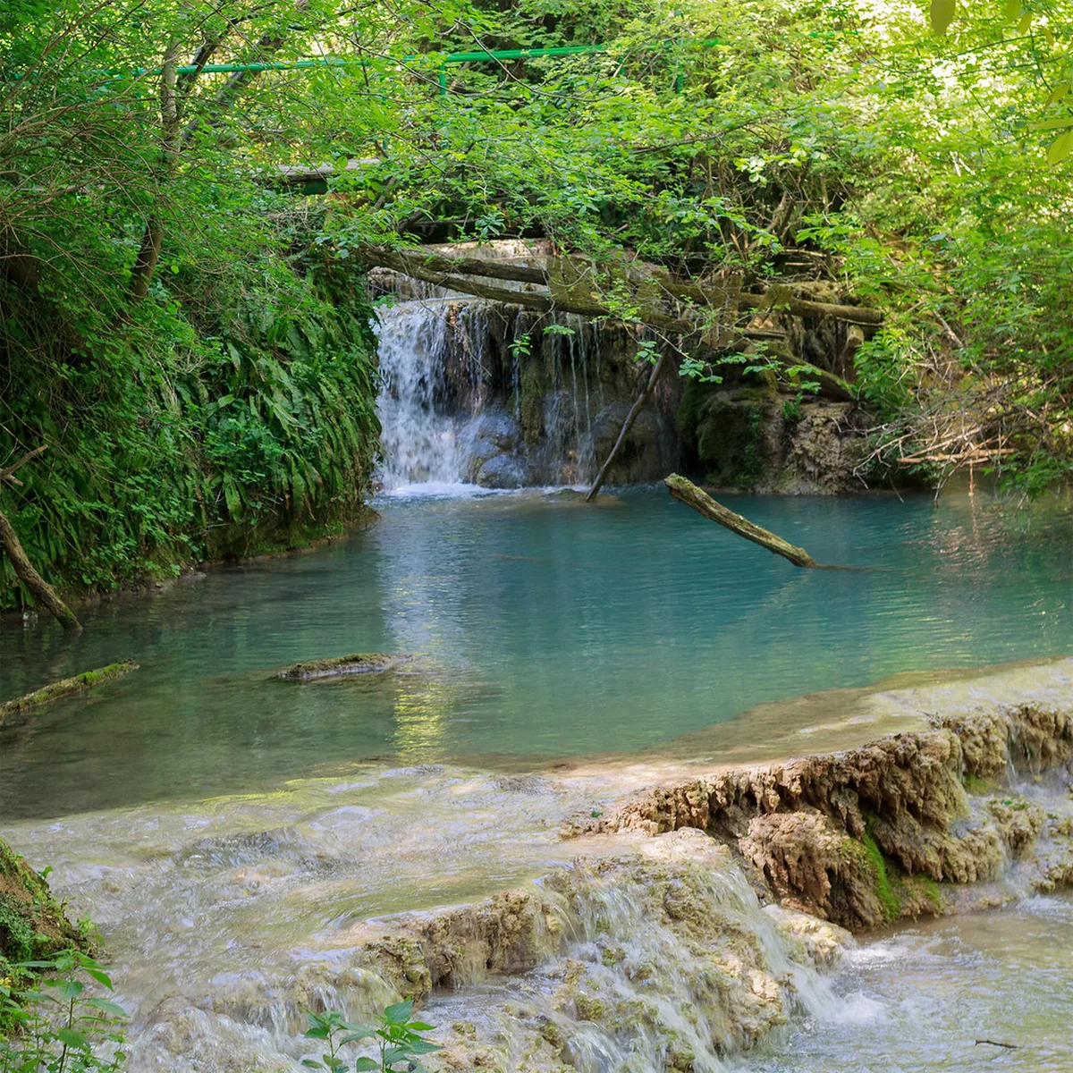 Turquoise travertine pools and cascades of the Krushuna Waterfalls in Bulgaria, fed by spring snowmelt