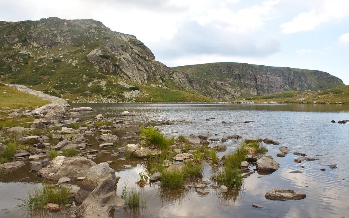 Jagged peaks and glacial waters of Rila Mountains in Bulgaria with snow-capped summits