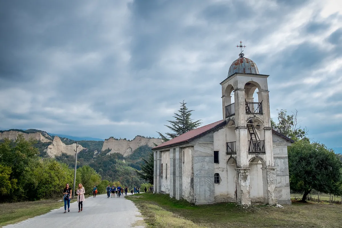 The wooden galleries and vine-draped courtyard of Rozhen Monastery in the Pirin Mountains of Bulgaria